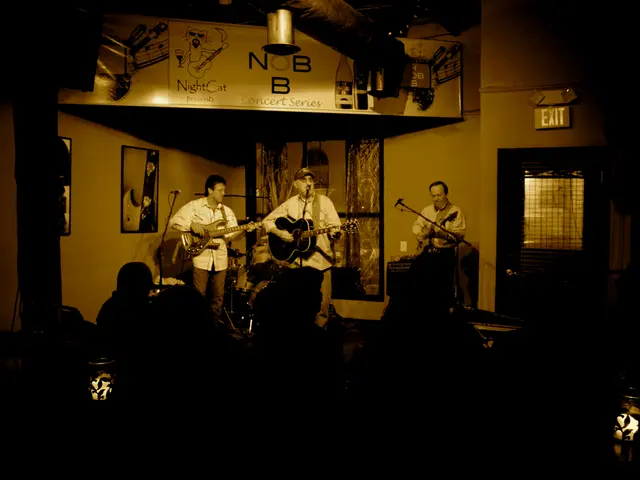 This is inside a room. few people are playing guitar. In front of them there is mic. They are...